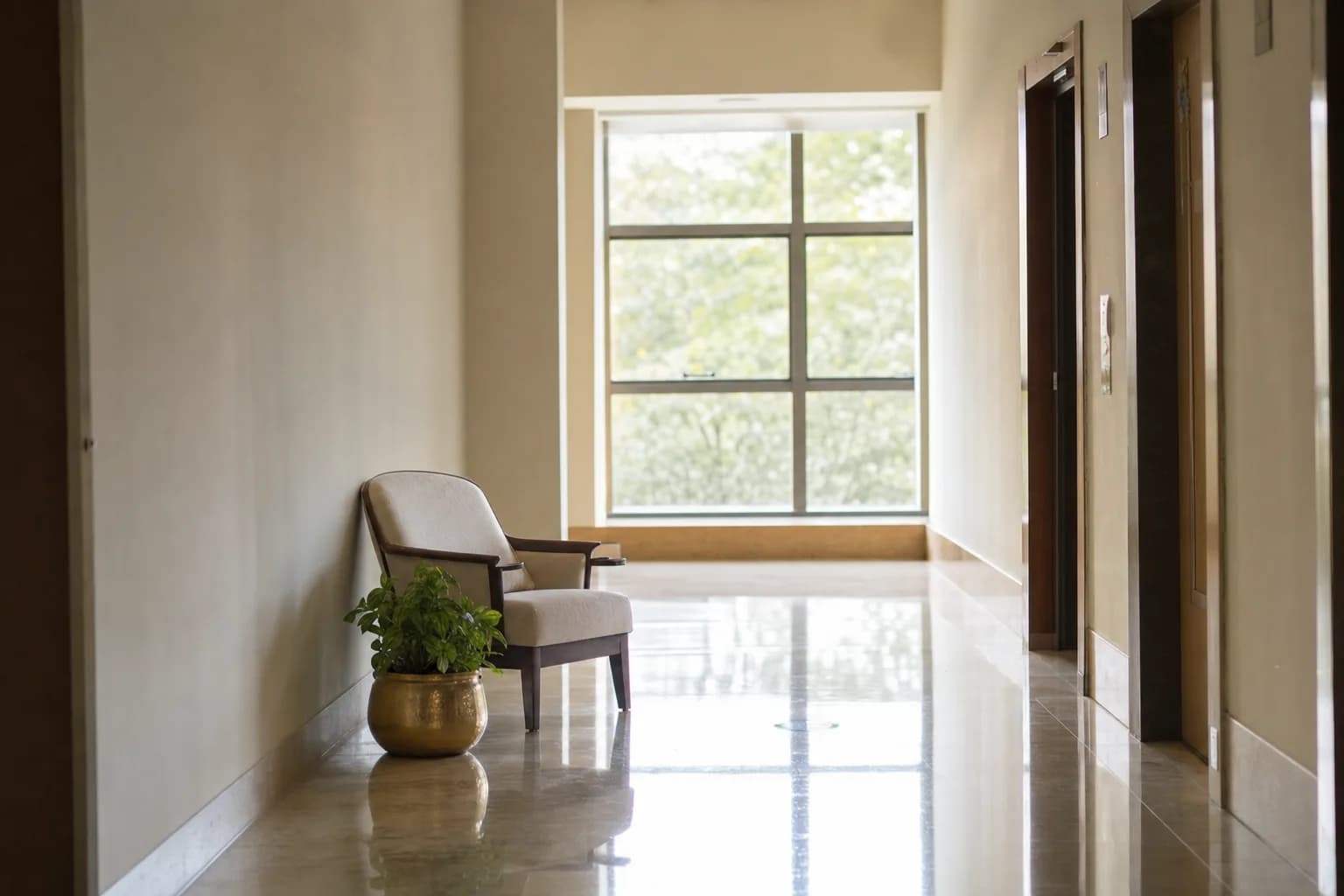 Calm hospital wing hallway with cream floors and natural light