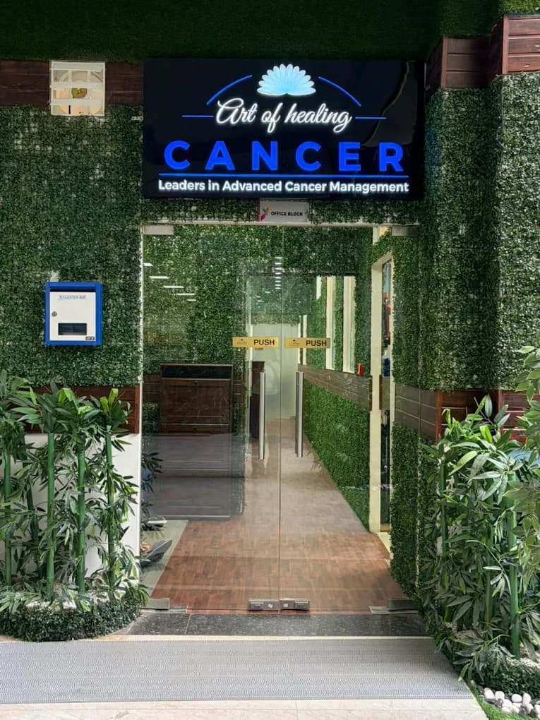 Art of Healing Cancer centre entrance with illuminated signage and landscaped greenery